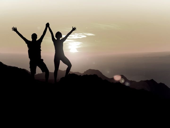 a couple standing on the top of the mountain