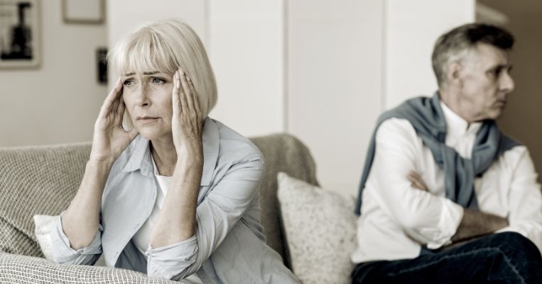 a couple sitting side by side not talking to each other